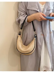 Détail sac porté épaule en paille tissée chic, sac hobo tendance pour un look quotidien.