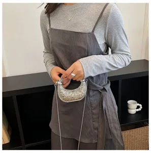 Silver crescent chain crossbody bag detail shot, glittering sequin finish for stylish wear.