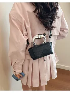 Detailaufnahme einer trendigen Damen Schulter Umhängetasche mit silbernem Griff und Struktur.
