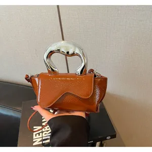 Braune Lackleder Handtasche Detailansicht mit einem einzigartigen silbernen Kunstgriff Design.