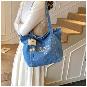 Gedetailleerd aanzicht van casual Koreaanse stijl denim tote bag met borduursel en pluche hangertje.