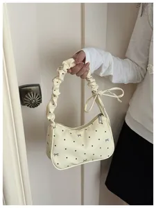 Chic ruched underarm bag with cute polka dots and bow details, stylish cream yellow purse.