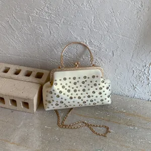 Élégante pochette pour femmes avec fermoir bijou, strass, poignée dorée et chaîne.