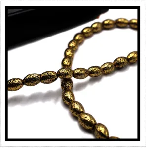 Detailed close-up of electroplated gold lava stone drum beads, perfect for DIY jewelry making.