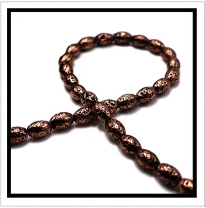 Close-up detail of electroplated bronze lava stone barrel beads, ideal for DIY jewelry.