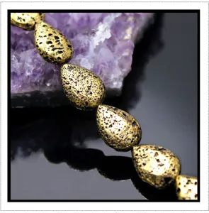 Macro close-up detail of electroplated gold teardrop lava stone beads DIY accessory.
