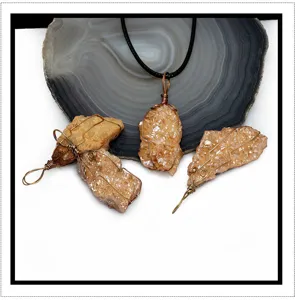 Detailed view of irregular raw crystal cluster pendant with copper wire wrapping and black cord.