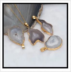 Gedetailleerd overzicht van natuurlijke agaat geode hangers met ruwe steen en goudrand.