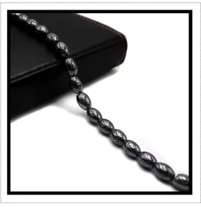Detailed close-up of electroplated lava stone drum beads strand, unique textured surface finish.
