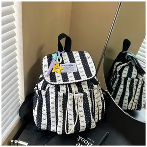 Black and white striped backpack detail with bow pattern, drawstring and cute pendant.