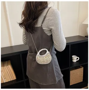 Detail view of the stylish crescent evening bag with glittering rhinestones and metal handle.