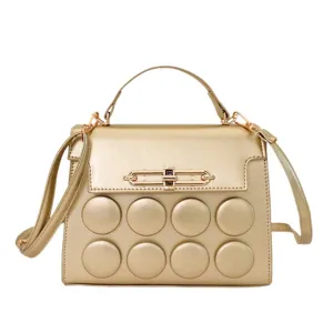 Elegant golden top handle shoulder crossbody bag for women with stylish metal lock and puffs.