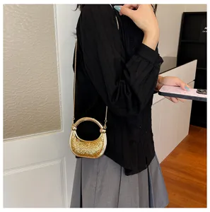Stylish shiny mini crossbody bag for women with gold metal ring handle and chain strap.