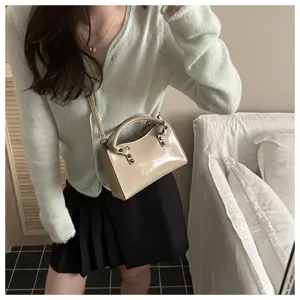 Beige patent leather shoulder handbag detail view, showing soft texture and premium hardware.