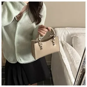 Detail view of stylish oil wax leather mini handbag with metal rings, chic motorcycle style.