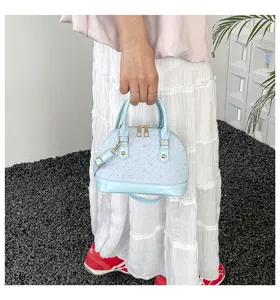 Sac coquillage bleu clair imprime d'etoiles, elegant detail de sac bandouliere femme.