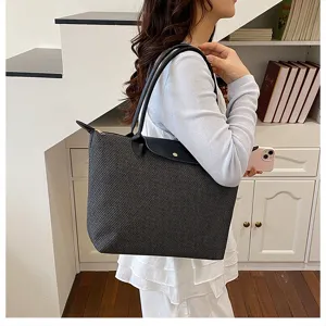 Detailed view of stylish women's black textured tote bag featuring durable leather handles for daily.