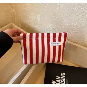 Pochette en toile rayée rouge et blanche, trousse de maquillage élégante détail.