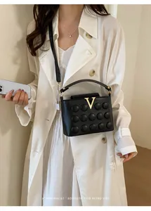 Borsa a tracolla nera con fibbia dorata a V, borsa a mano chic e moderna per donne.