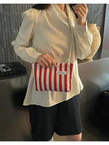 Pochette pour femme rayée rouge et blanche, sac cosmétique élégant et accessoire de mode quotidien.