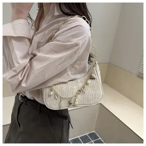 Woven straw shoulder bag, trendy chain baguette handbag with pearl shell charms for summer.