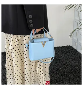 Sac à main bandoulière bleu clair chic avec logo V doré, sac tendance pour la mode du printemps.