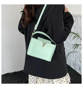 Vue détaillée d'un sac à bandoulière vert clair élégant avec un fermoir métallique en V chic.