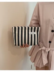 Vue détaillée d'une trousse en toile à rayures noires et blanches, pochette élégante de mode.