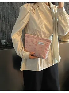 Pochette zippée rayée rose pour femme, sac à main tendance avec imprimé nœud et design minimaliste.