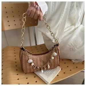 Straw woven underarm shoulder bag with gold chain and shell charms, chic beach summer handbag.