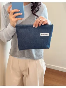 Détail de pochette en denim, petit sac décontracté bleu pour femmes avec étiquette blanche.