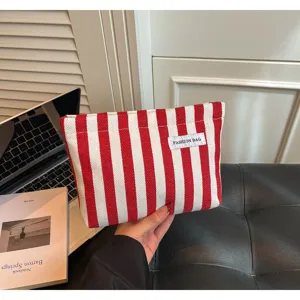 Détail de la pochette en toile rayée rouge et blanc, sac de rangement quotidien élégant.