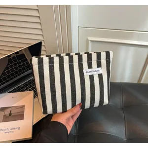 Pochette clutch en toile rayée noir et blanc, trousse de maquillage minimaliste pour femmes.