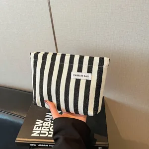 Chic sac pochette pour femme à rayures noir et blanc, sac décontracté élégant de couleur contrastée.