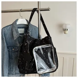 Primo piano della borsa ita nera con stampa di stelle, finestra trasparente e ciondolo.