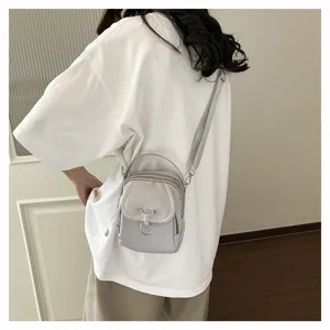 Borsa a tracolla in nylon grigio dettaglio, design compatto con tasche pratiche da donna.