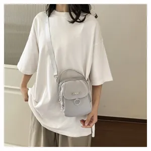 Dettaglio borsa a tracolla in nylon grigio, borsetta telefono casual con manico e anello.