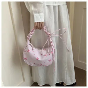 Dettaglio borsa a spalla hobo rosa con stampa di fiocchi e manico arricciato chic.