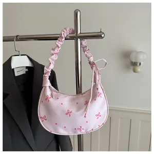 Borsa a spalla rosa con graziosa stampa di fiocco e tracolla arricciata per uso quotidiano.