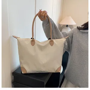 Large capacity casual travel tote bag featuring stylish brown leather trim detail.