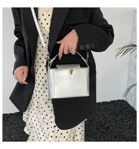 Élégant sac à bandoulière argenté avec logo V en métal, idéal pour un look chic et quotidien.