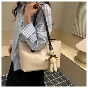 Borsa a tracolla grande capacità donna colore a contrasto con ciondolo orsetto.