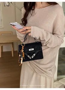 Elegant black suede Kelly handbag for women, retro top handle bag with metal clasp.