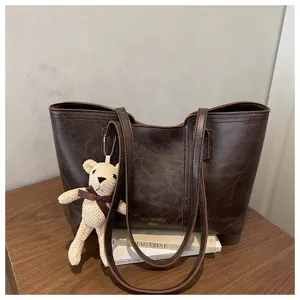 Classica borsa shopper in pelle marrone scuro con simpatico ciondolo orsetto per lavoro e tempo.