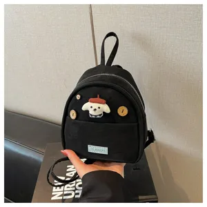 Détail du mini sac à dos noir avec un charmant patch de chiot et des boutons en bois.