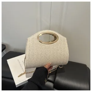 Vista dettagliata della borsa in paglia intrecciata con manico ovale e catena dorata.