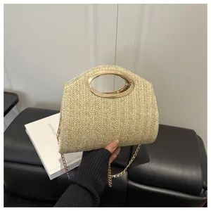 Borsa a tracolla in paglia intrecciata con manico ad anello in metallo e catena elegante.