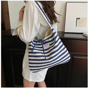 Detail shot of womens casual blue and white striped canvas tote bag with drawstring.