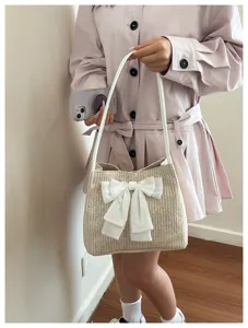 Detail view of woven straw shoulder bag featuring an elegant white bow and large capacity design.