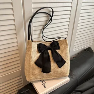 Stylish straw woven tote bag for women with black bow and shoulder straps, casual chic main view.